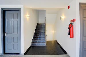 a hallway with a staircase with a red coat on the wall at OYO Townhouse Deva Road Lucknow in Lucknow