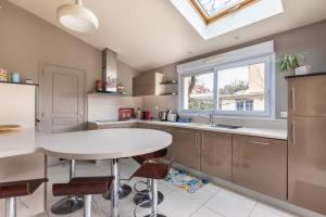 a kitchen with a table and a window at Maison Ferrer - avec jardin clos in Villeneuve-le-Roi +4 photos