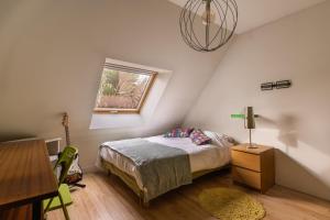 a bedroom with a bed and a window and a table at Maison Ferrer - avec jardin clos in Villeneuve-le-Roi