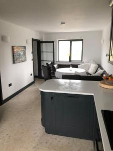 a kitchen and living room with a couch and a table at Gwel Owrek in Tintagel