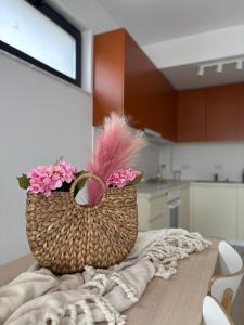 a basket with pink flowers sitting on top of a table at Warm apartament 3 in Bucharest +8 photos
