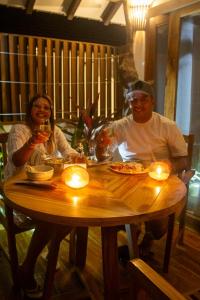 a man and woman sitting at a table with wine glasses at Primaluna Romantica in La Punta de los Remedios +62 photos