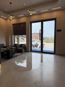 a living room with a large sliding glass door at Hotel Eastleigh in Ludhiana