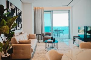a living room with a couch and chairs and a television at Stunning 1 Bed in Trilogy, Limassol Seafront in Limassol