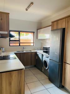 a kitchen with a refrigerator and a washer and dryer at The blyde 1 bedroom in Pretoria