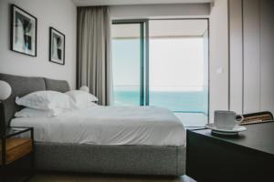 a bedroom with a bed with a view of the ocean at Stunning 1 Bed in Trilogy, Limassol Seafront in Limassol