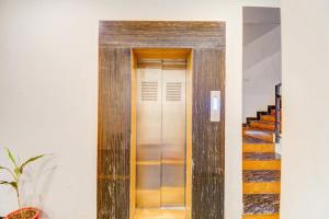 a wooden elevator in a building with stairs at Palette by CheckIn Goverdhan Villas Formerly The White Fresco in Udaipur