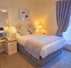 a bedroom with a bed with two lamps and a phone at Waterloo Lodge in Dublin +23 photos