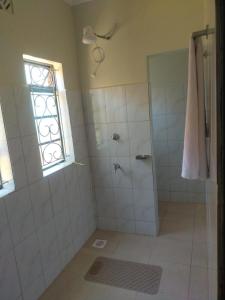 a bathroom with a shower with a glass door at Green Garden in Juja