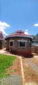 a small brick house with a road in front of it at Green Garden in Juja