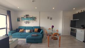 a living room with a blue couch and a table at AL Sunset in Albufeira