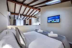 a bedroom with a white bed and a tv at Garibaldi Luxury apartments in Prato