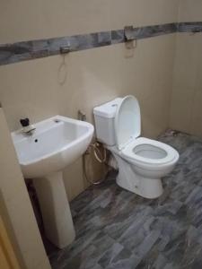 a bathroom with a white toilet and a sink at Tha Ivory villa in Nattarampota