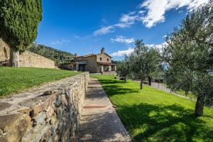 a stone wall in front of a house at YD exclusive design villa Agati in Castiglion Fiorentino