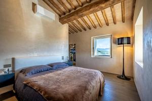 a bedroom with a large bed and a window at YD exclusive design villa Agati in Castiglion Fiorentino