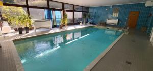 a large swimming pool with blue water in a building at Tiny Atelier Leihfahrräder Gratis Shuttleservice in Bad Harzburg