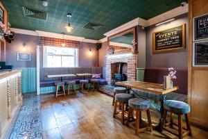ein Restaurant mit einem Tisch und Hockern in einem Raum in der Unterkunft Cherry Tree in Horbury