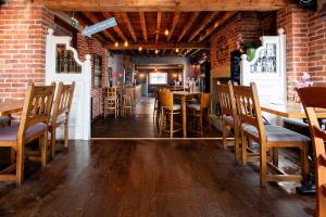 ein Restaurant mit Holztischen und -stühlen und einer Backsteinmauer in der Unterkunft Cherry Tree in Horbury + 10 Fotos