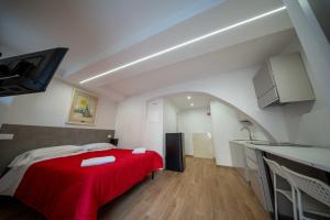 a bedroom with a red bed and a kitchen at Perugia Apartments in Perugia