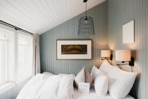 a bedroom with a bed with white pillows at Nusfjord Village & Resort in Nussfjord
