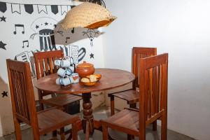 a wooden table with chairs and an umbrella over it at Vila Borogodó- Casa in Barra Grande
