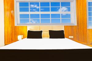 a bedroom with a large bed with a window at Super Collection O Adajan Formerly Hotel Western Inn in Surat +39 photos