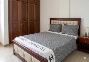 a bedroom with a large bed with a wooden headboard at 2 chambres residence Dovv quartier Odja in Yaoundé