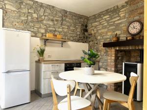 a kitchen with a table and chairs and a stone wall at Agriturismo Cascina Lella in Varzi