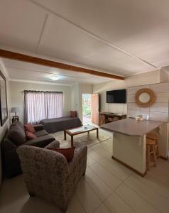 a living room with a couch and a table at East Gate Rest Camp in Buitepos