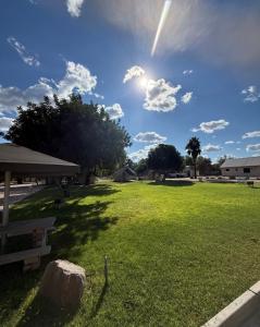a grassy field with the sun in the sky at East Gate Rest Camp in Buitepos