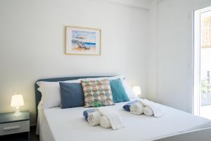 a bedroom with a white bed with towels on it at Residence Casuzze in Marina di Ragusa +177 photos