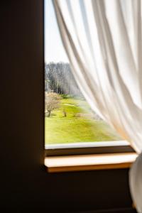 a window with a view of a green field at Hôtel & Restaurant Five Nations in Durbuy