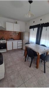 a kitchen with a table and chairs in a kitchen at Complejo el Cuy in Las Grutas