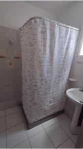 a bathroom with a shower curtain with writing on it at Complejo el Cuy in Las Grutas