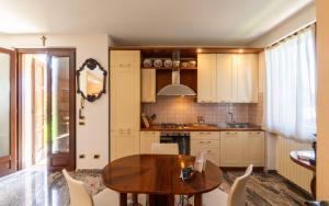 a kitchen with a wooden table and chairs at Villa Infinity Garda in Peschiera del Garda