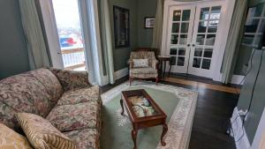 a living room with a couch and a table at Rose & Thistle B&B Lunenburg in Lunenburg