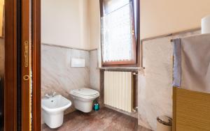 a bathroom with a toilet and a sink and a window at Villa Infinity Garda in Peschiera del Garda +40 photos