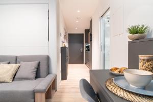 a living room with a couch and a table at City Pop 2Night Geneva - Self check-in in Geneva