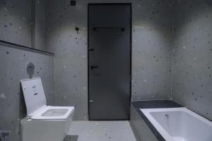 a bathroom with a toilet and a bath tub at Srushti Resort in Daulatābād +46 photos