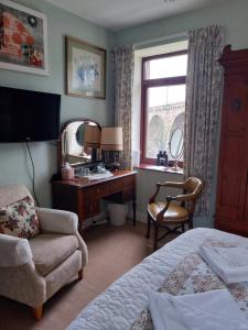 a bedroom with a bed and a desk and a chair at Castle Vale House in Berwick-Upon-Tweed