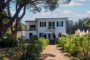 a large white house with green shutters at Il Golfo e La Spiaggia - A Due Passi Da Procchio in Marciana