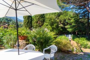 a table and two chairs with an umbrella at Il Golfo e La Spiaggia - A Due Passi Da Procchio in Marciana