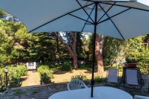 an umbrella sitting on a table with chairs at Il Golfo e La Spiaggia - A Due Passi Da Procchio in Marciana
