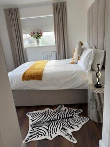 a bedroom with a bed with a zebra rug on the floor at Hillcrest House Holiday Suites in Donegal