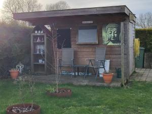 a small shed with a statue of a head at Chalet in menaam in Dronrijp