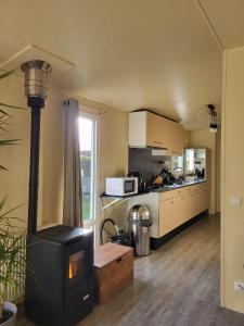 a kitchen with a stove in the middle of a room at Chalet in menaam in Dronrijp