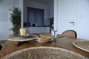 a wooden table with plates of food and a glass of water at Loreto Apartment in Bragança +10 photos