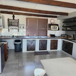 a kitchen with a sink and a counter with wooden doors at 51onStirling in De Kelders +17 photos