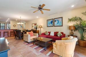 a living room with red couches and a ceiling fan at Vibrant 3-Bedroom Condo with Resort Amenities, Pools & Beach Club Access in Coco