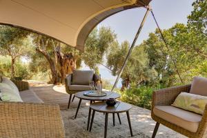 an outdoor patio with chairs and a table at Amavi Luxury Tent Corfu in Víngla